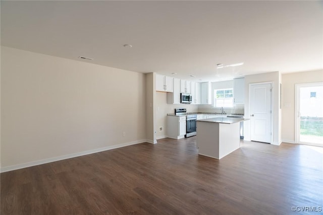 kitchen with stainless steel appliances, dark wood-style flooring, a center island, and white cabinetry