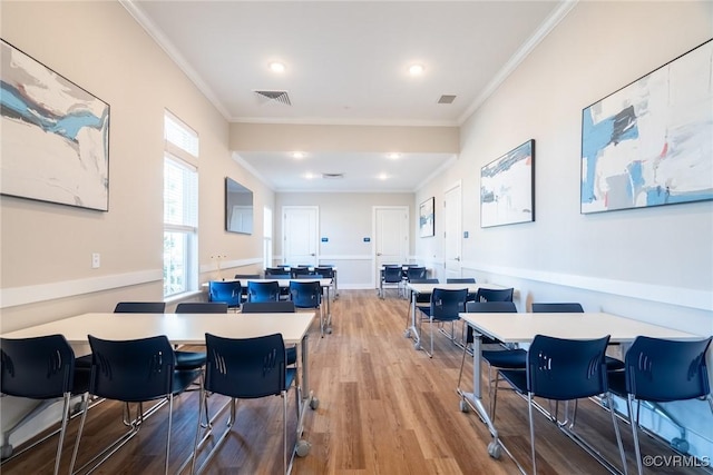 rec room with wood finished floors, visible vents, and ornamental molding