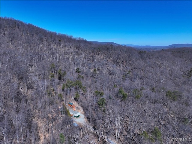 birds eye view of property featuring a mountain view and a view of trees