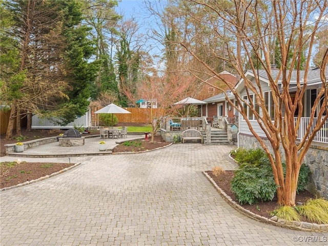 view of home's community with a patio, decorative driveway, and a wooden deck