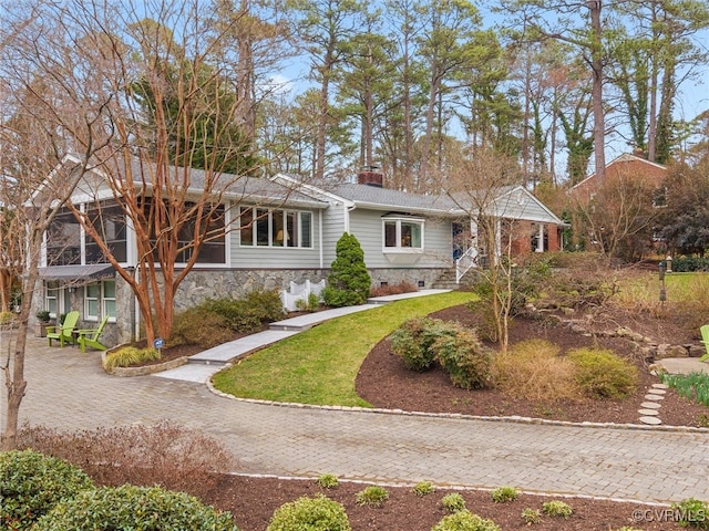 view of front of house with crawl space, a chimney, and a front yard