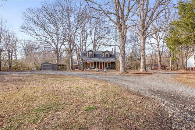 view of front of house with an outbuilding, a storage unit, and covered porch