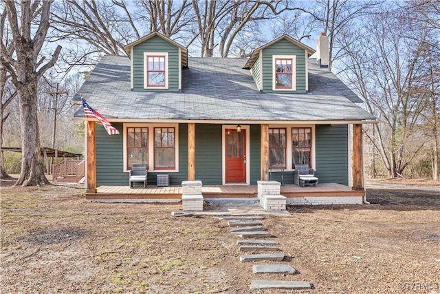 view of front facade featuring covered porch and a chimney