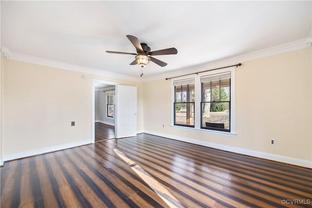 empty room with baseboards, dark wood-type flooring, and crown molding