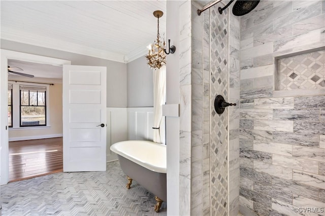 full bathroom with tiled shower, a freestanding bath, ornamental molding, wainscoting, and a chandelier