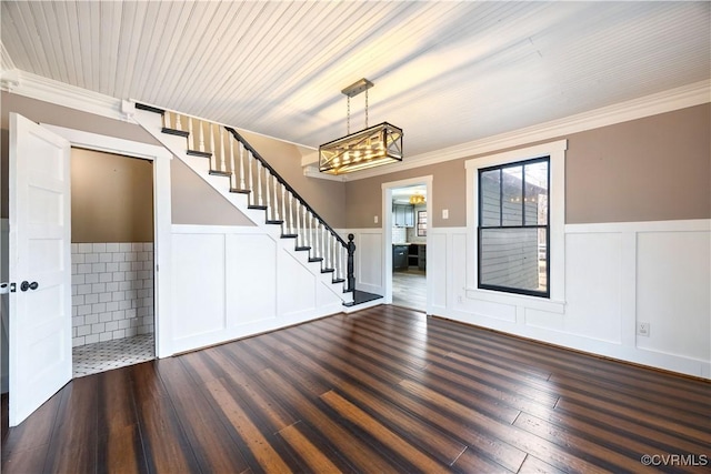 interior space with wainscoting, wood finished floors, stairs, and crown molding