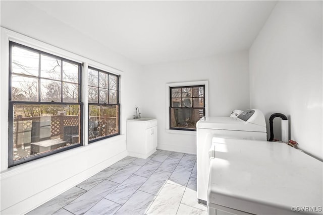 washroom with baseboards, laundry area, a sink, washing machine and dryer, and marble finish floor