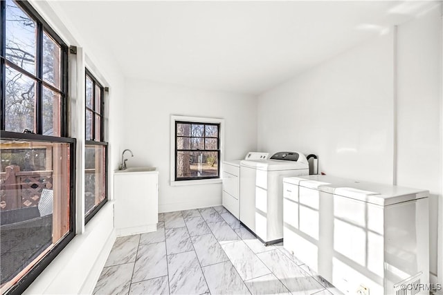 laundry area with washing machine and clothes dryer, marble finish floor, baseboards, and a sink