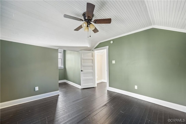 unfurnished bedroom with a ceiling fan, baseboards, lofted ceiling, dark wood-type flooring, and crown molding