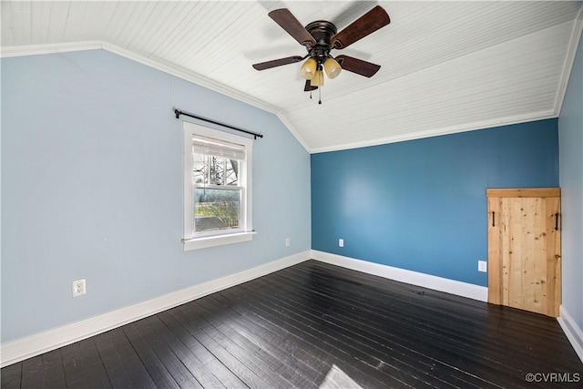 spare room with lofted ceiling, crown molding, dark wood-type flooring, and baseboards