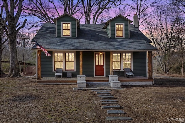 view of front facade with covered porch and a chimney