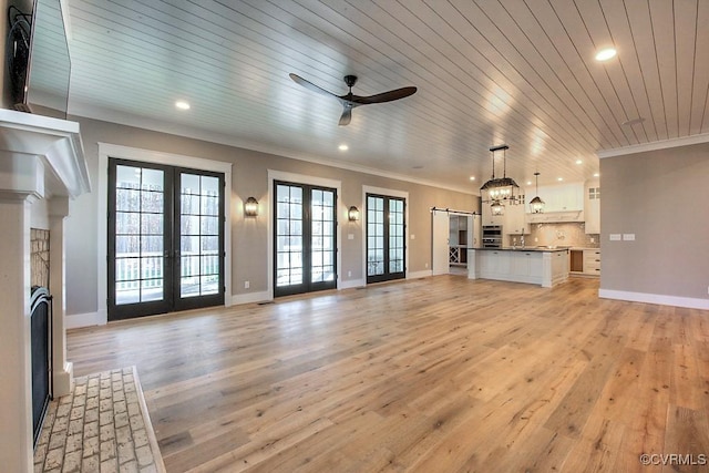 unfurnished living room with french doors, light wood-style floors, ceiling fan, and ornamental molding