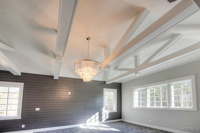 spare room featuring a chandelier, baseboards, wood walls, and vaulted ceiling with beams