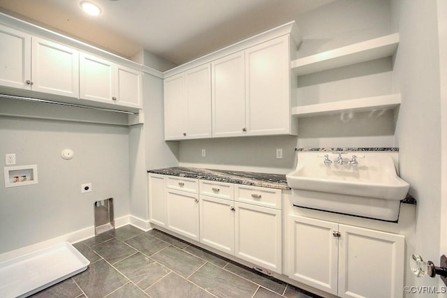 kitchen featuring open shelves, baseboards, white cabinets, and a sink