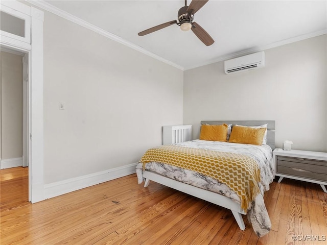 bedroom featuring a wall mounted air conditioner, crown molding, baseboards, and wood finished floors