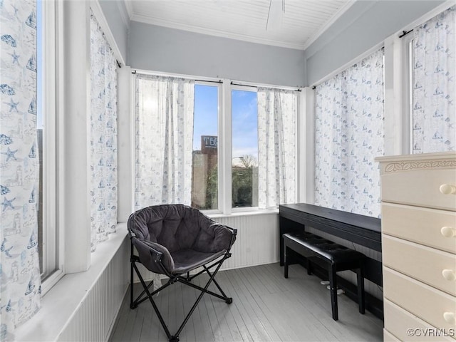 living area with hardwood / wood-style floors and crown molding