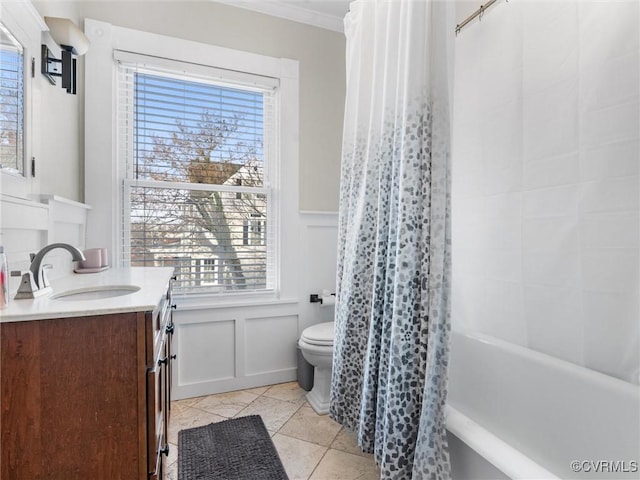 bathroom with crown molding, a wainscoted wall, toilet, a decorative wall, and vanity