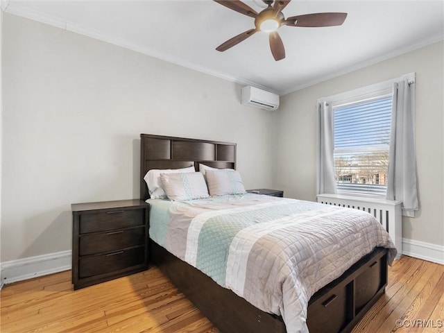 bedroom with radiator, crown molding, baseboards, light wood-type flooring, and a wall mounted AC