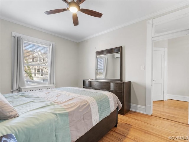 bedroom with a ceiling fan, crown molding, baseboards, and light wood-type flooring