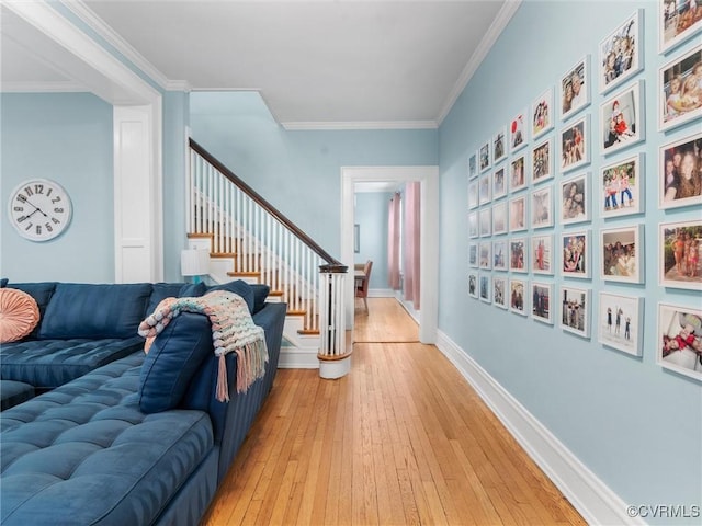 interior space featuring baseboards, ornamental molding, stairs, and light wood finished floors