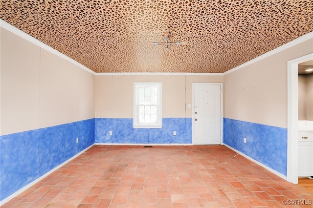 spare room featuring brick floor, a wainscoted wall, and ornamental molding