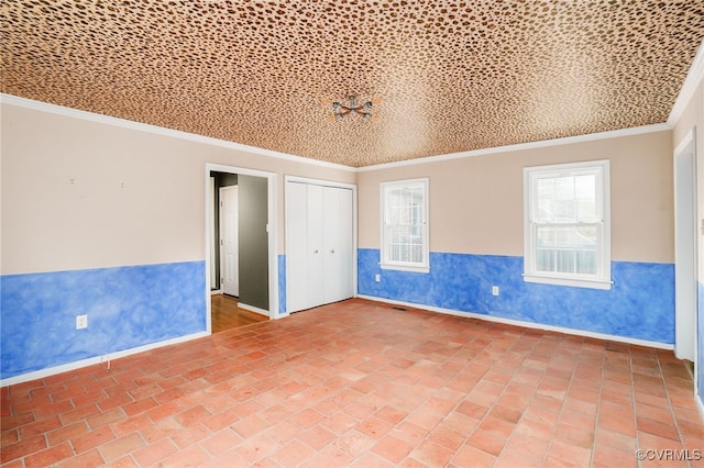 spare room with wainscoting, brick floor, and ornamental molding