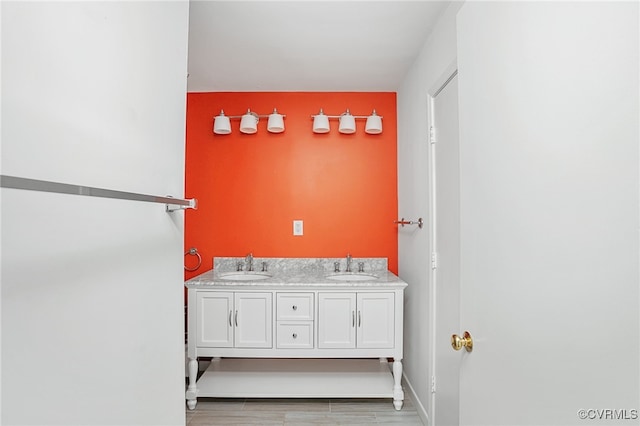 bathroom featuring double vanity, baseboards, and a sink