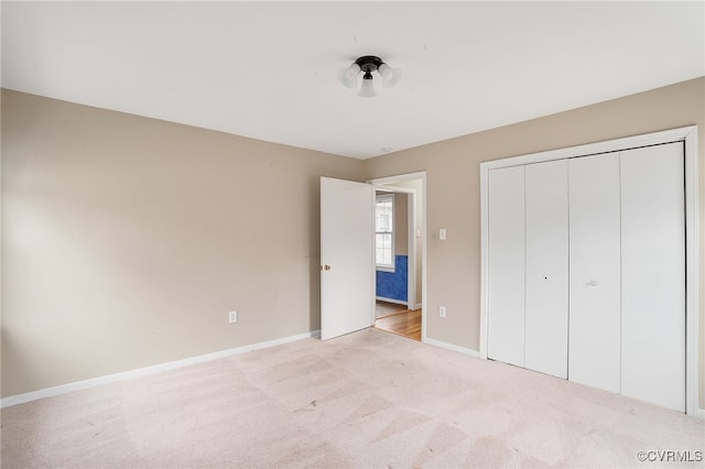 unfurnished bedroom featuring carpet flooring, baseboards, and a closet