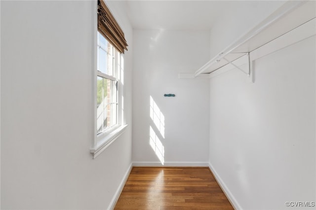 walk in closet with wood finished floors