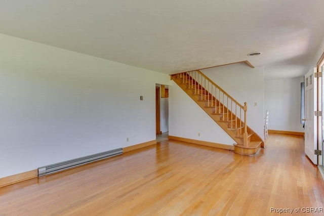 spare room with stairway, baseboards, visible vents, a baseboard radiator, and light wood-style floors