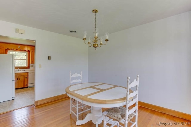 dining space with visible vents, baseboards, an inviting chandelier, and light wood-style flooring