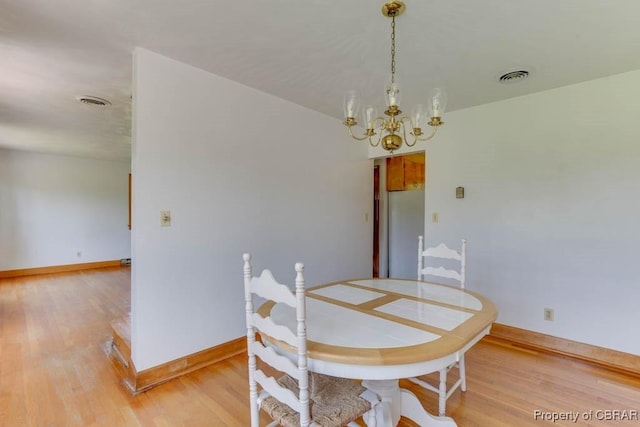 dining room with visible vents, baseboards, light wood-type flooring, and an inviting chandelier