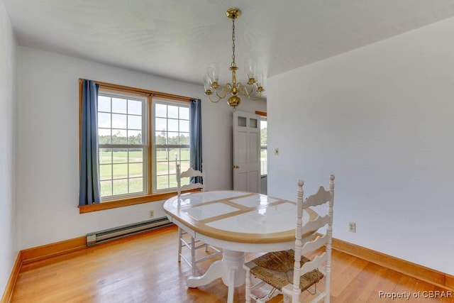 dining space featuring baseboards, baseboard heating, an inviting chandelier, and light wood finished floors