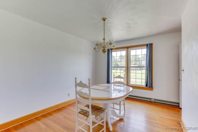 dining room featuring light wood-style flooring, a notable chandelier, baseboards, and baseboard heating