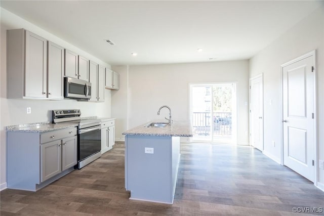 kitchen with wood finished floors, gray cabinetry, stainless steel appliances, and a sink