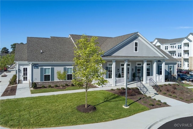 view of front of home with brick siding, a porch, and a front lawn