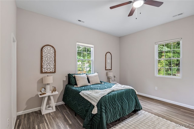 bedroom featuring wood finished floors, visible vents, and baseboards