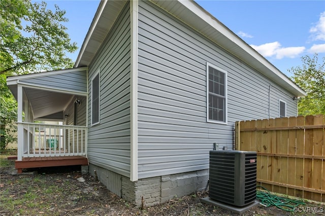 view of property exterior featuring cooling unit and fence