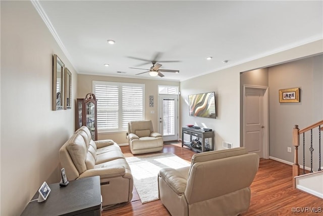 living room featuring visible vents, stairs, crown molding, and wood finished floors