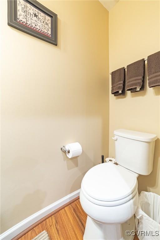 bathroom featuring toilet, baseboards, and wood finished floors