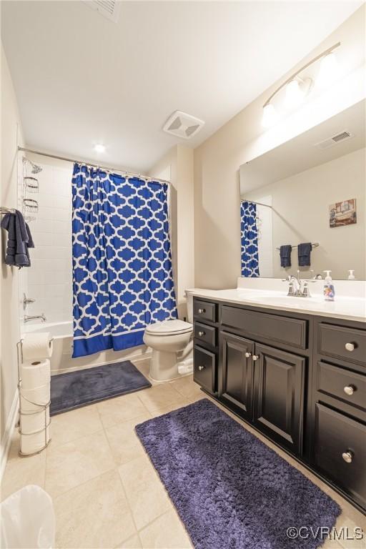 bathroom featuring visible vents, toilet, tile patterned floors, shower / bath combination with curtain, and vanity