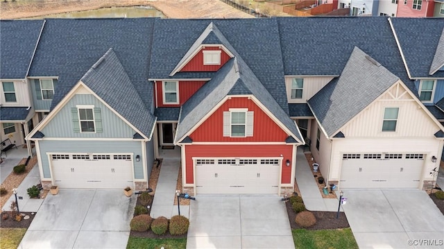 craftsman-style home with board and batten siding, concrete driveway, a garage, and a shingled roof