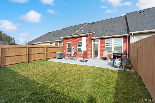 rear view of property featuring central air condition unit, a lawn, a patio, a fenced backyard, and a shingled roof