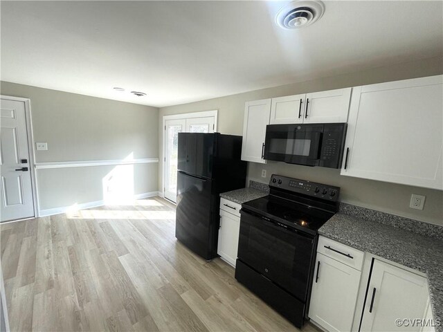 kitchen featuring baseboards, light wood finished floors, black appliances, and white cabinetry