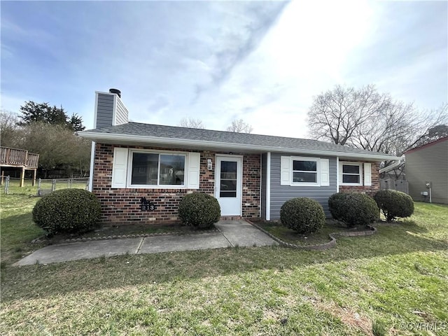 ranch-style house featuring brick siding, a chimney, a front yard, and fence