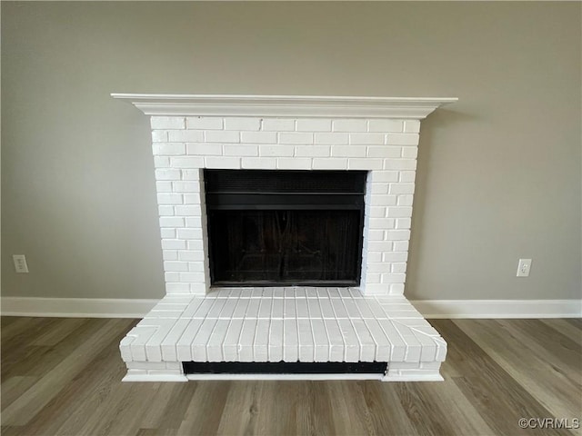 room details with a fireplace, baseboards, and wood finished floors