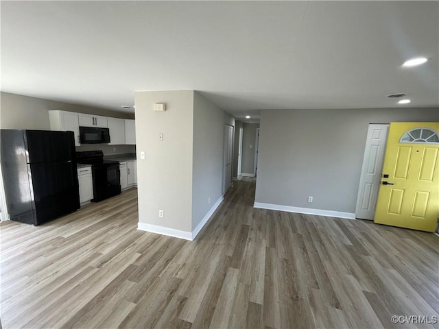 unfurnished living room featuring recessed lighting, baseboards, and light wood-type flooring