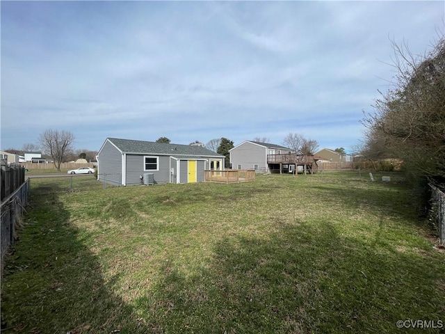 view of yard featuring an outbuilding, cooling unit, a wooden deck, and a fenced backyard