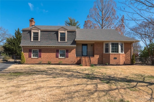 tri-level home featuring fence, roof with shingles, a chimney, a front lawn, and brick siding