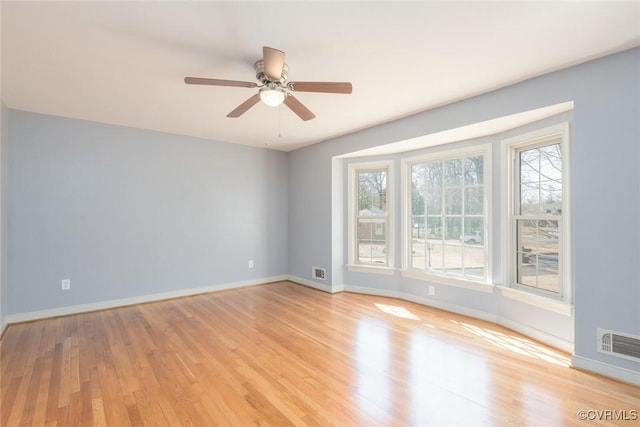 spare room featuring visible vents, baseboards, light wood-style floors, and ceiling fan